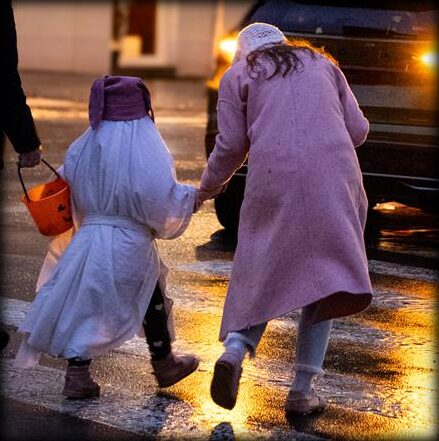A child and a parent walking hand in hand to the next stop