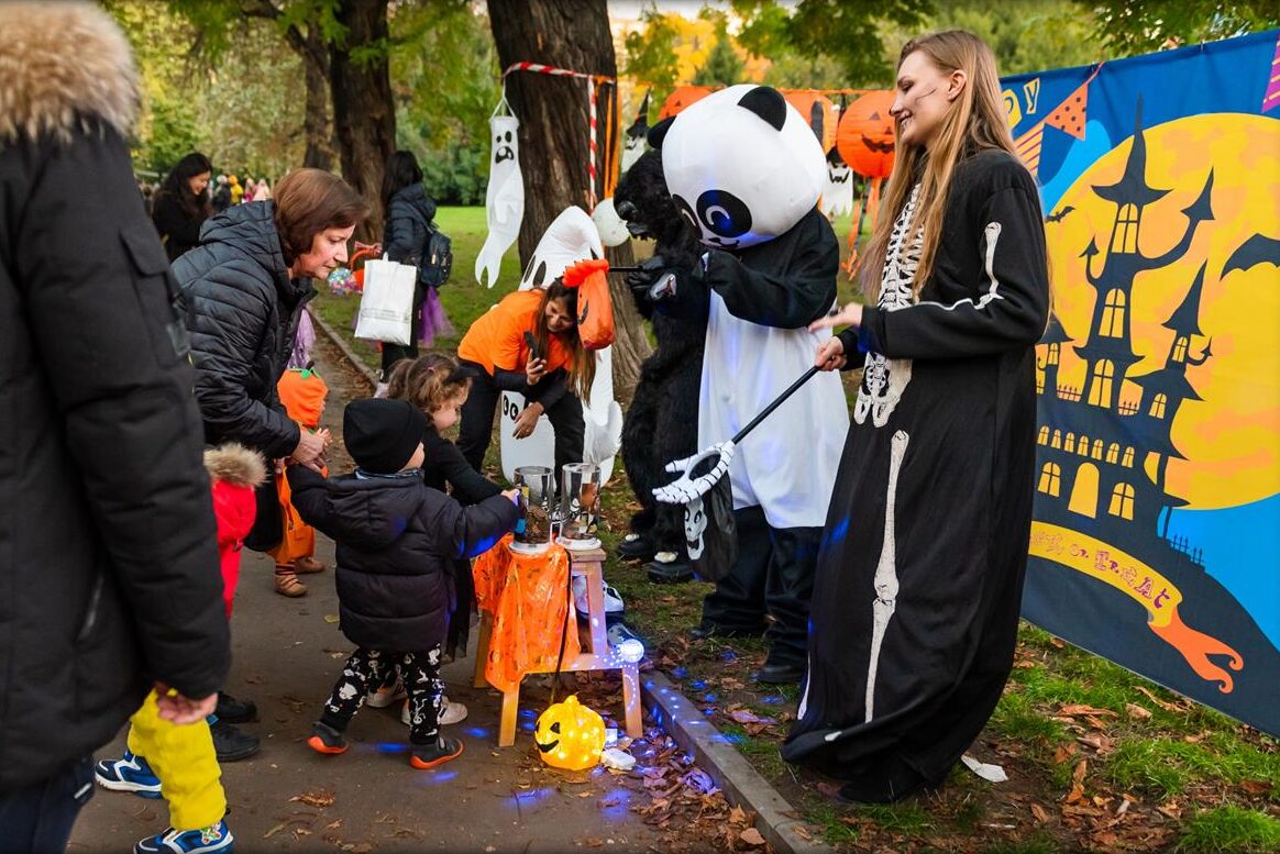 A panda mascot greeting children at a stop in the park